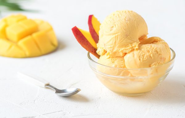 Mango Ice Cream or Sorbet in bowl. Homemade fruit mango ice cream on white background, copy space.